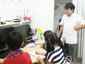 院長と絵を描いている子供たちの写真